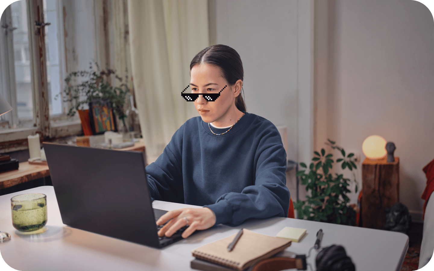 Девушка в мультяшных очках за столом с ноутбуком
